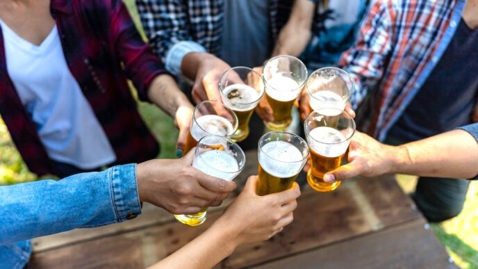 Persona sosteniendo una copa de vino representando el debate sobre el consumo diario de alcohol
