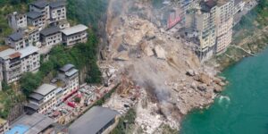 Vista aérea del deslizamiento de tierra en el condado de Pengshui, Chongqing, China, mostrando edificios destruidos y escombros esparcidos en la ladera junto al río Wujiang