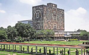 Fachada de la Universidad Nacional Autónoma de México con estudiantes en el campus universitario