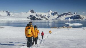 Crucero de expedición polar navegando entre hielo con tecnología de velas solares y propulsión híbrida sostenible